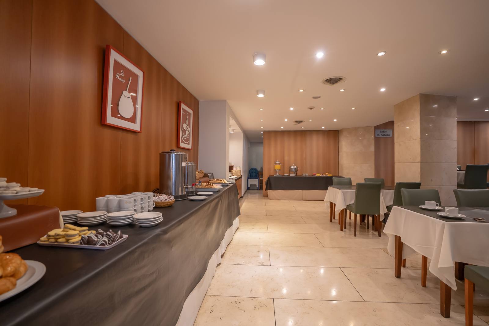 Salón del restaurante en planta baja, con las mesas preparadas y el mostrador del buffet
