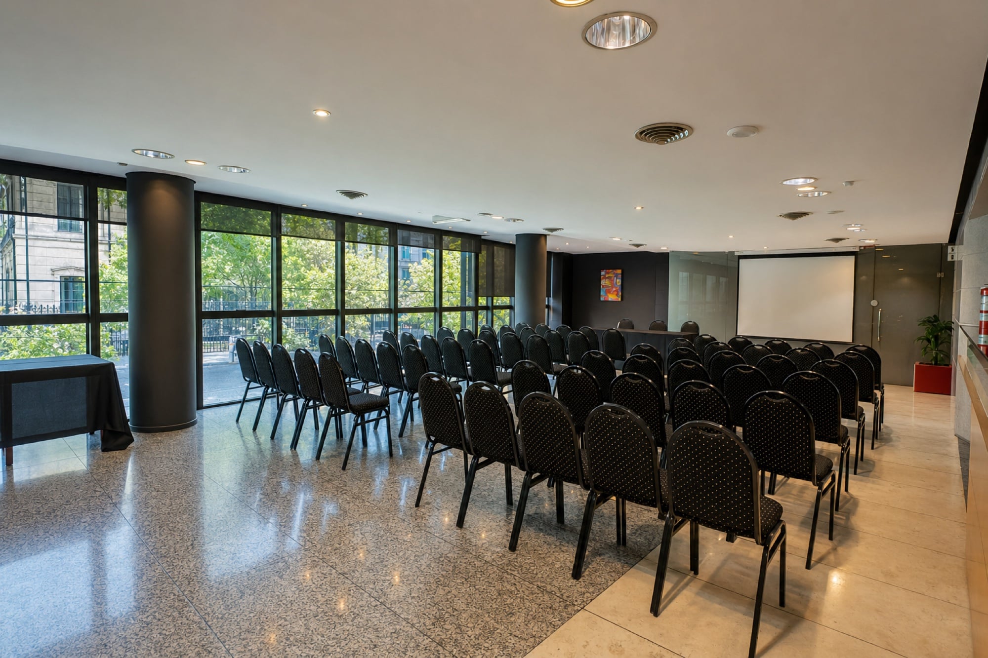 Salón Cortázar en armado auditorio, con el ventanal a la calle y la pantalla al fondo
